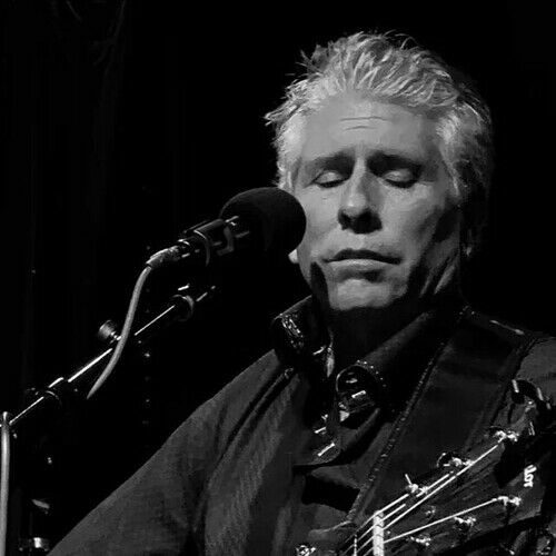 Black and white portrait of Tim McGeary singing into a microphone