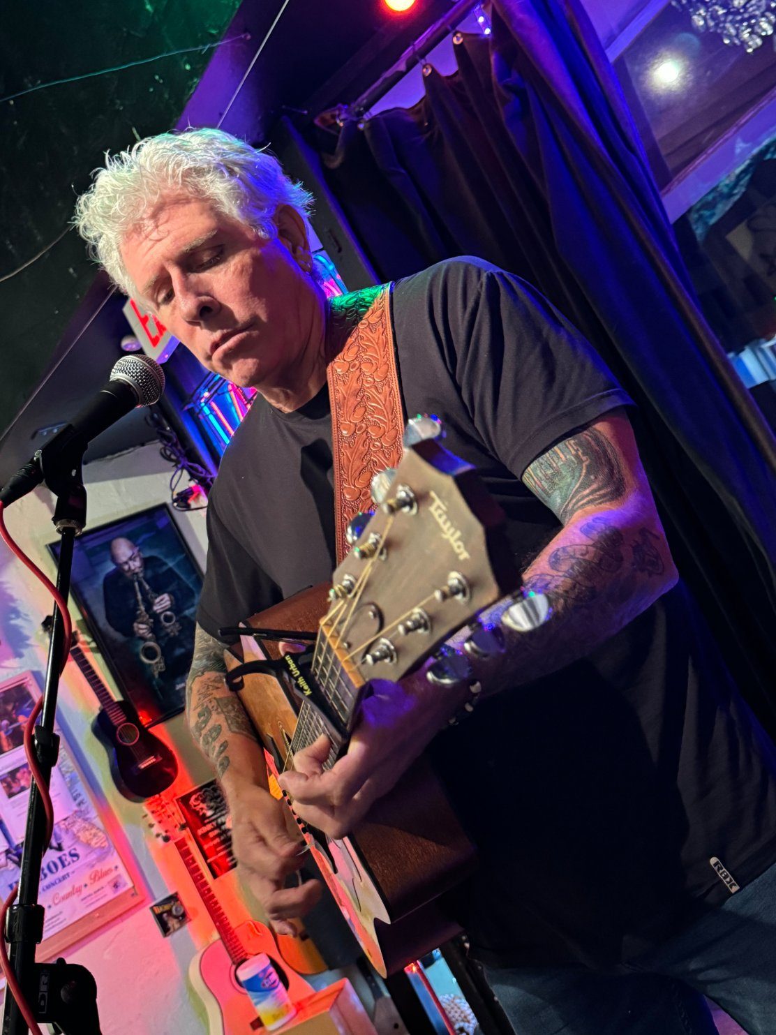 Tim McGeary playing acoustic guitar live on stage